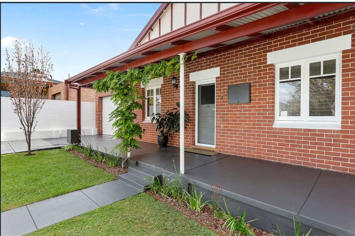 Concrete steps with handrail leading up to a covered home entrance